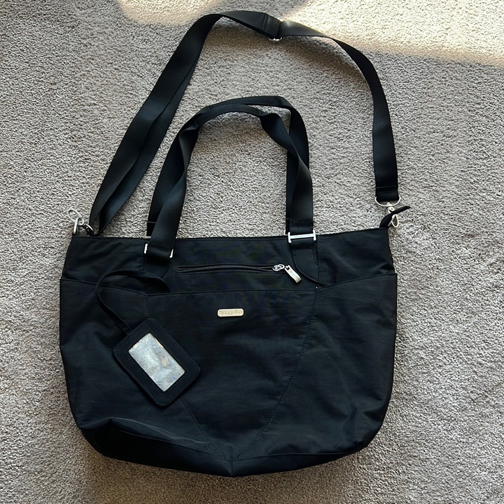 Baggallini black tote- multiple pockets. Trolley sleeve. Used once. No stains.